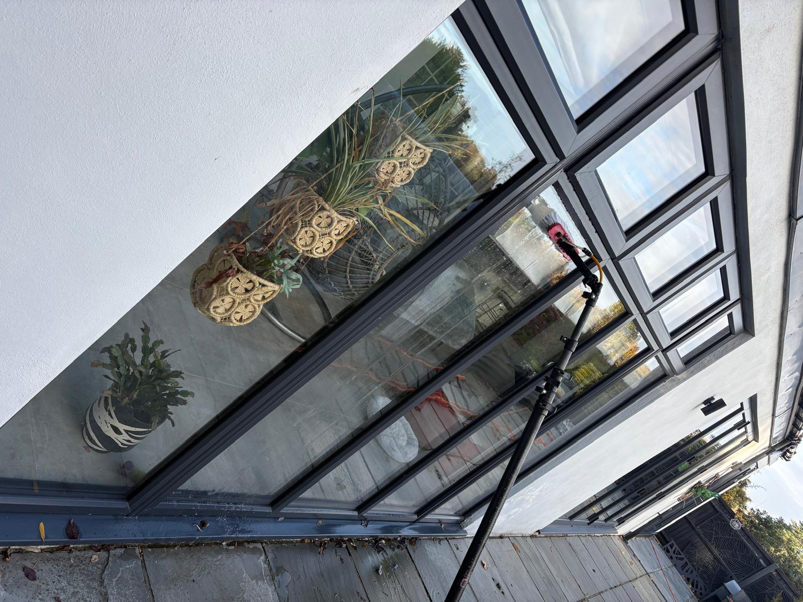 KC Cleaning Solutions cleaning windows with a water-fed pole