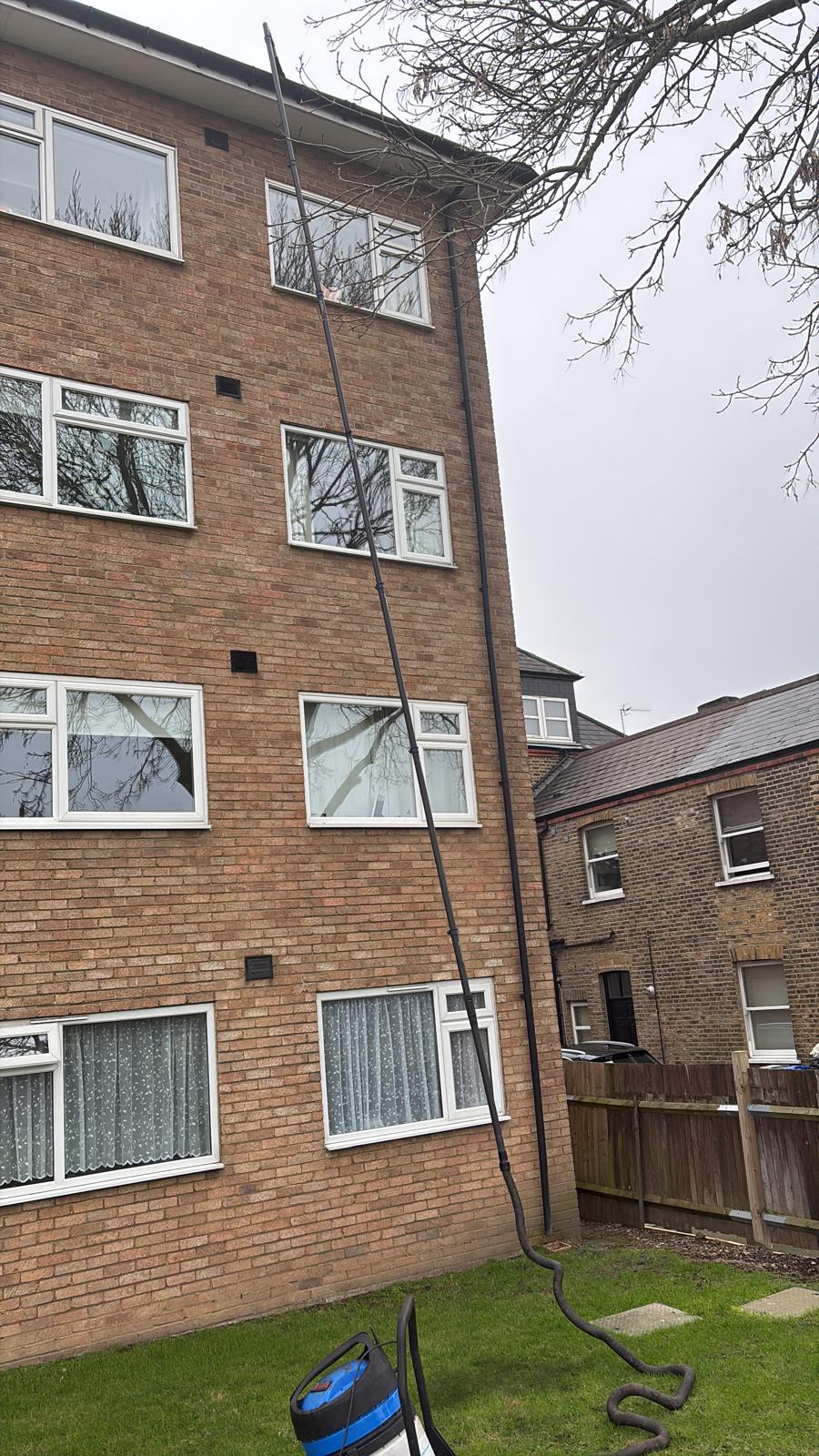 Gutter vacuum reaching an upper-storey gutter